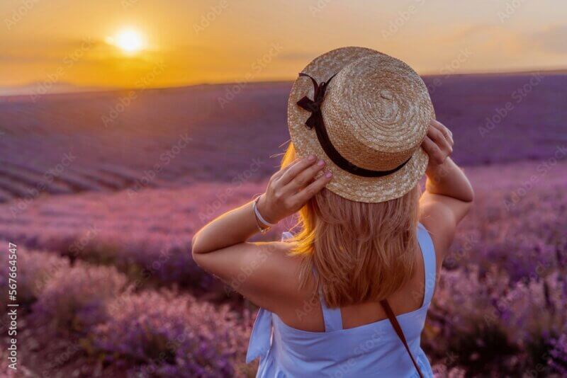 5 Tips for Handling Eczema During the Summer | Expert Advice 3 Woman lavender field sunset. Romantic woman walks through the lavender fields. illuminated by sunset sunlight. She is wearing a blue dress with a hat.