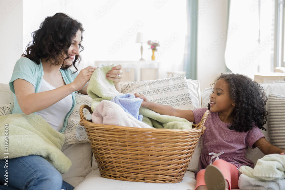 Mother and daughter folding laundry